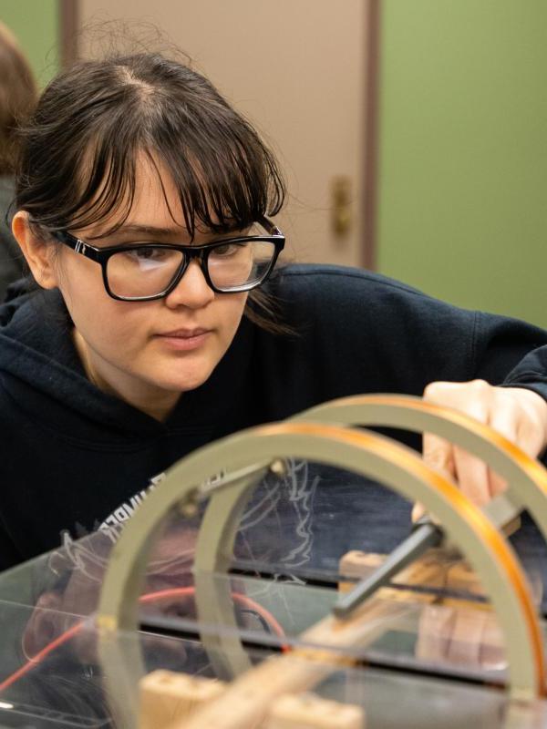 An undergraduate student conducts and electric magnetic physics experiment.